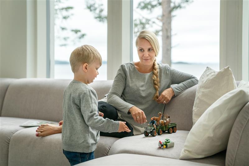Nainen ja lapsi leikkivät Iskun Babe-sohvalla junalelulla.