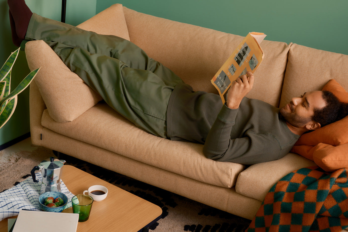 Mies pötköttelee Iskun sohvalla